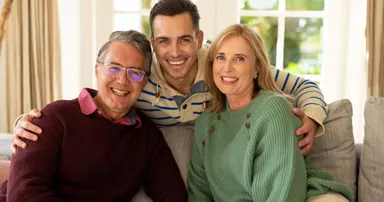 Son with senior parents in fremont bonding in the living room