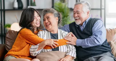 Elderly couple relaxing at home in Alameda and sharing a precious family moment with their adult daughter