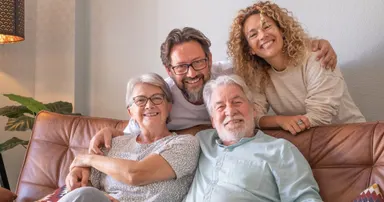 happy family in Berkeley sitting in sofa home relaxing and spending time together including parents and adult children